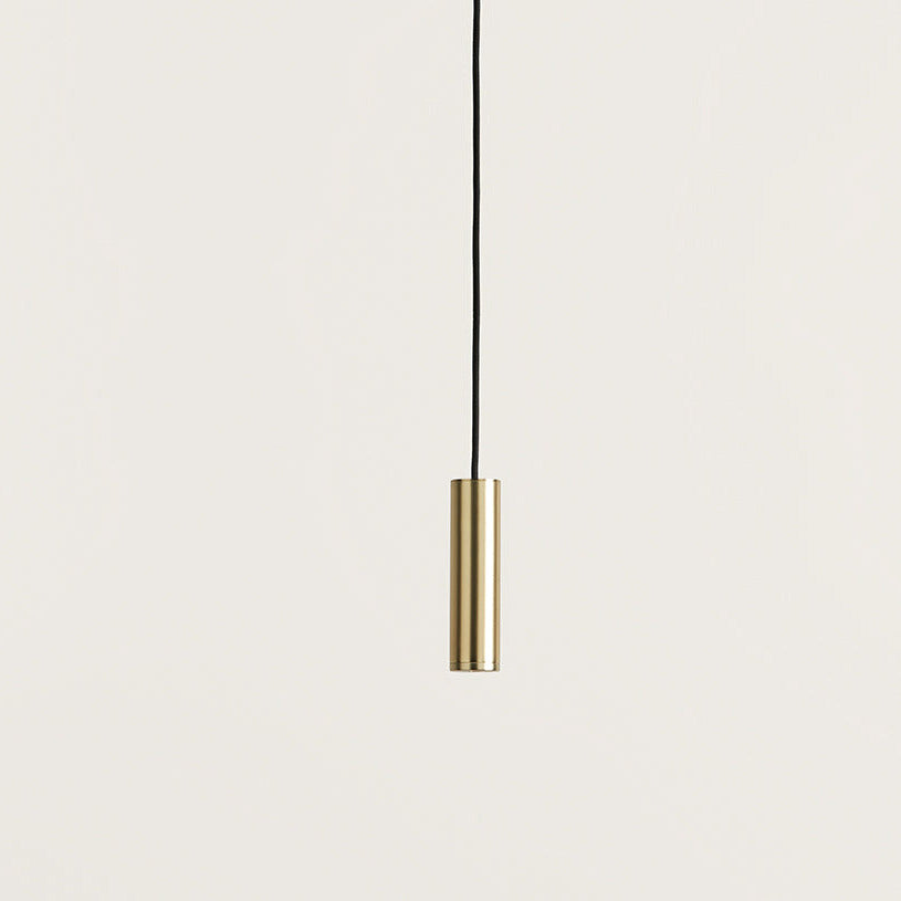 Close-up of the Maru Pendant Lamp brass cylinder shade on its black cord