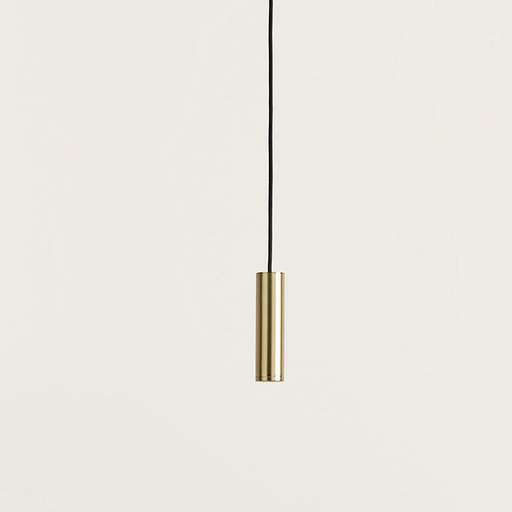Close-up of the Maru Pendant Lamp brass cylinder shade on its black cord