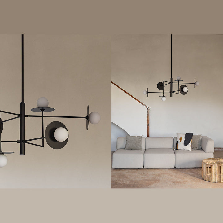 Black frame pendant with opal globes and dark discs above a cream sofa, with close-up inset