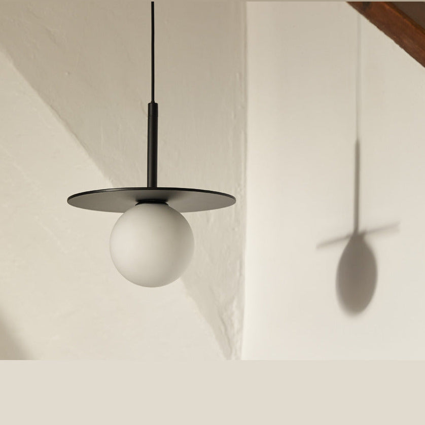 Miro Pendant Lamp (set) single pendant with black disc and opal globe casting a shadow on a white wall