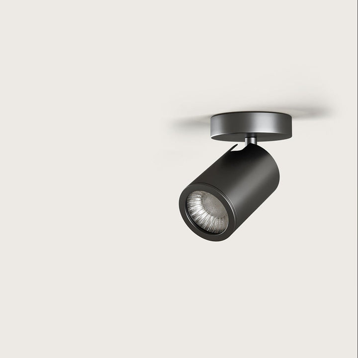 Noon Spot, dark steel cylindrical ceiling spotlight on a round canopy, unlit, by Aromas del Campo