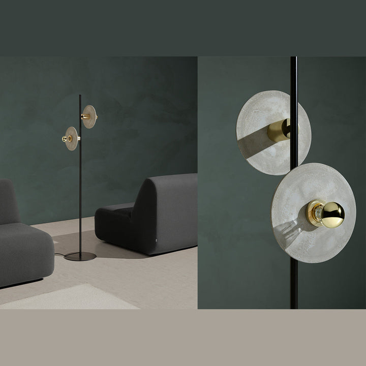 Ohlala Floor Lamp with clear textured glass discs beside a grey lounge chair against a green wall