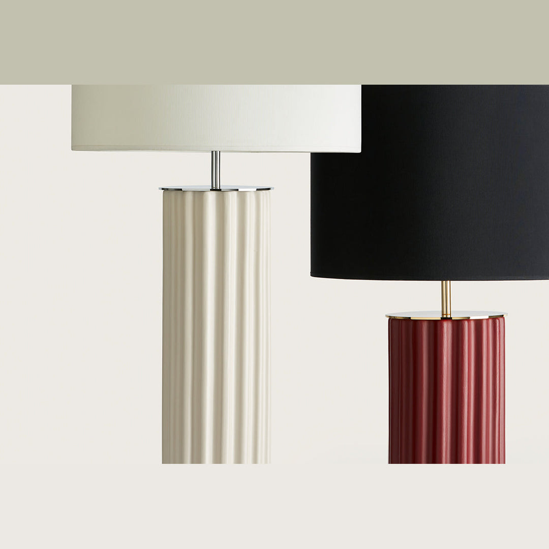 Two fluted ceramic bases, cream with white shade and burgundy with black shade, side by side