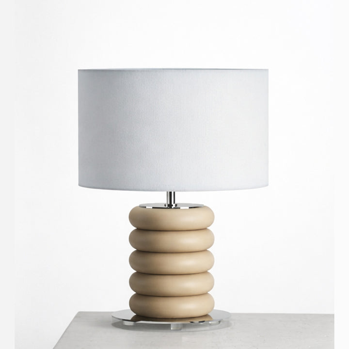 Onut Table Lamp with sand-beige stacked ceramic base and white drum shade on a stone plinth
