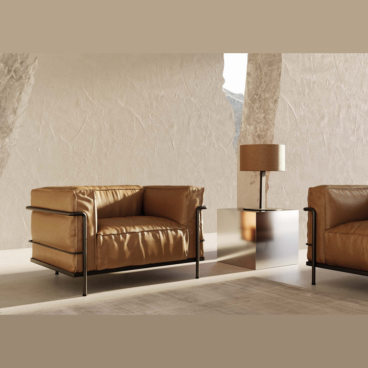 Tan shade lamp on a side table between two cognac leather club chairs