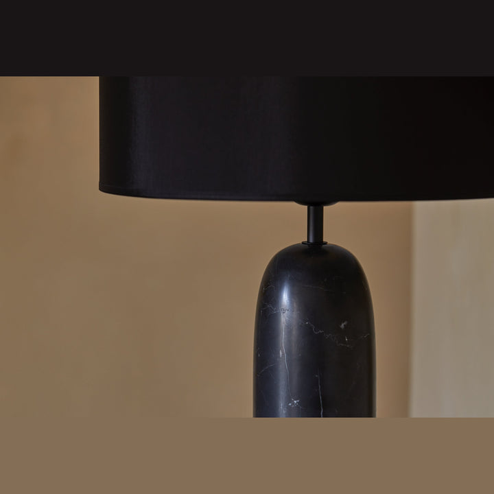Shin Table Lamp close-up of the black marble base veining beneath the black drum shade