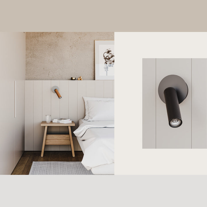 Tura Wall Lamp as a bedside reading light above a wooden nightstand, with a black leather close-up