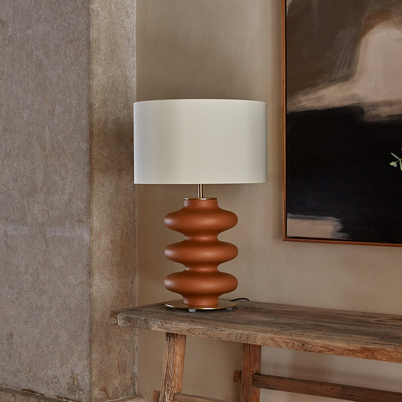 Adon Table Lamp with terracotta ceramic base and white shade on a rustic wooden console