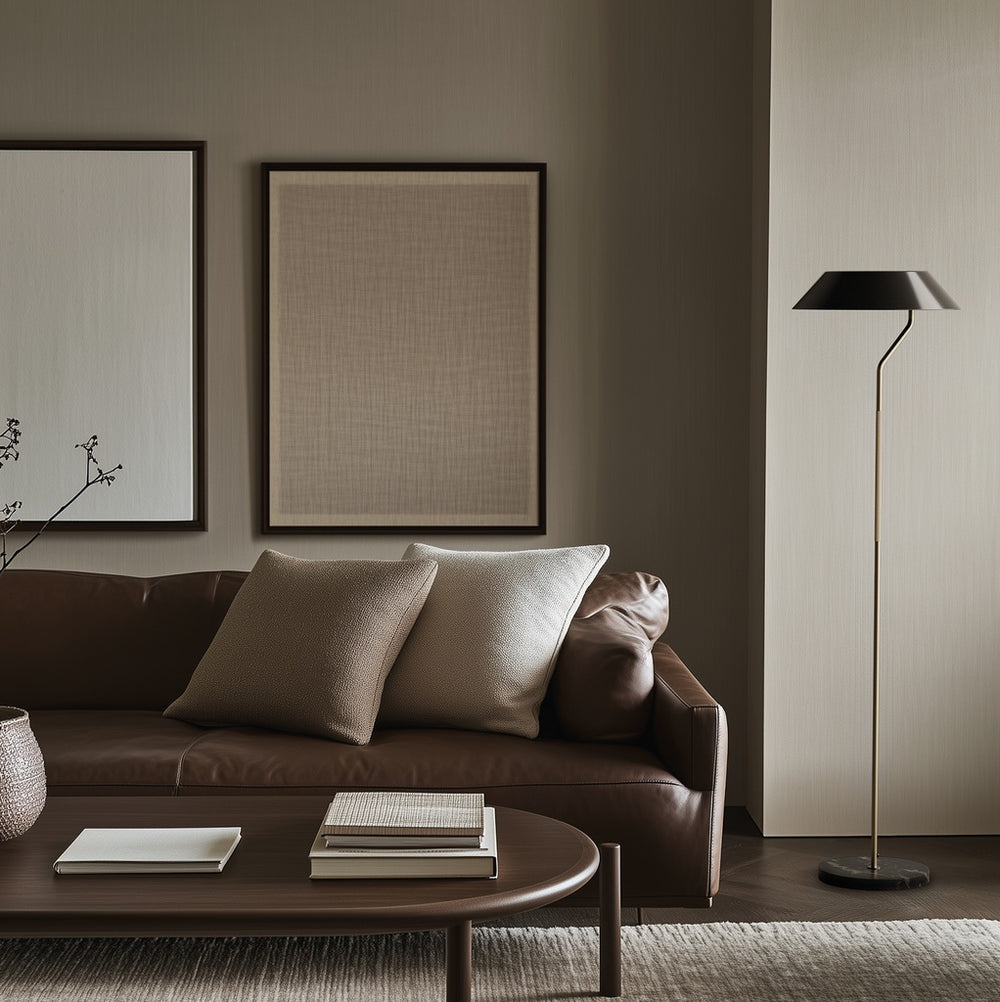 Aider Floor Lamp beside a brown leather sofa and oval coffee table in a muted living room