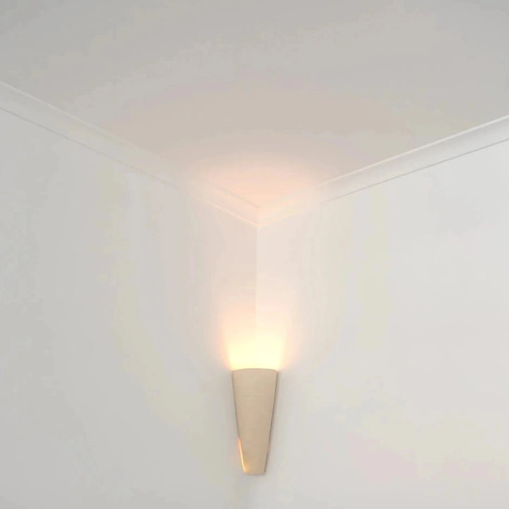 Still Lines Ceramic Wall Sconce — installed in a room corner, light washing up onto the ceiling molding