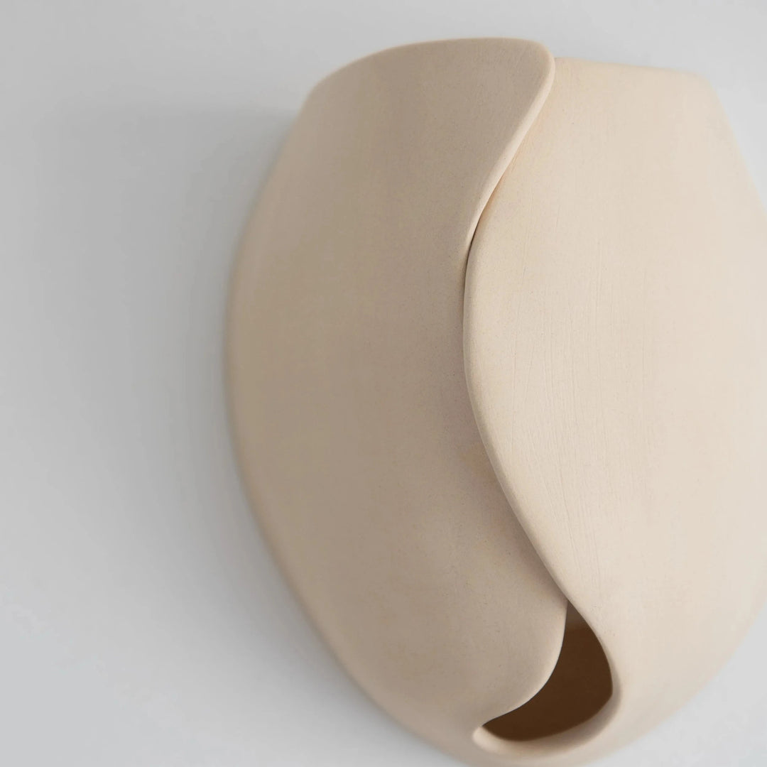 Sanctuary II Ceramic Wall Sconce — White Stoneware, angled detail of the swirl cutout