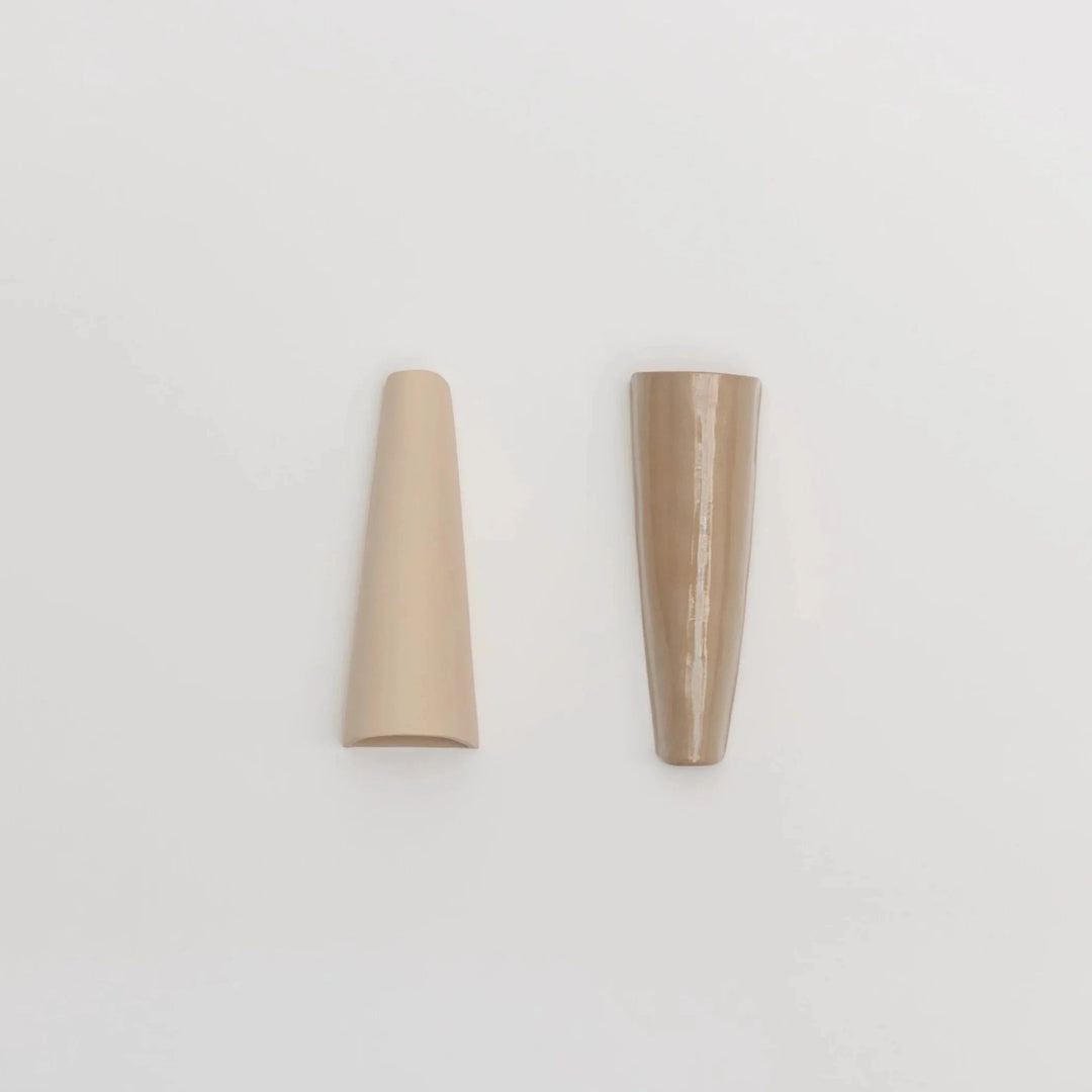 Still Lines Ceramic Wall Sconce — matte sand and glossy toffee finishes shown side by side