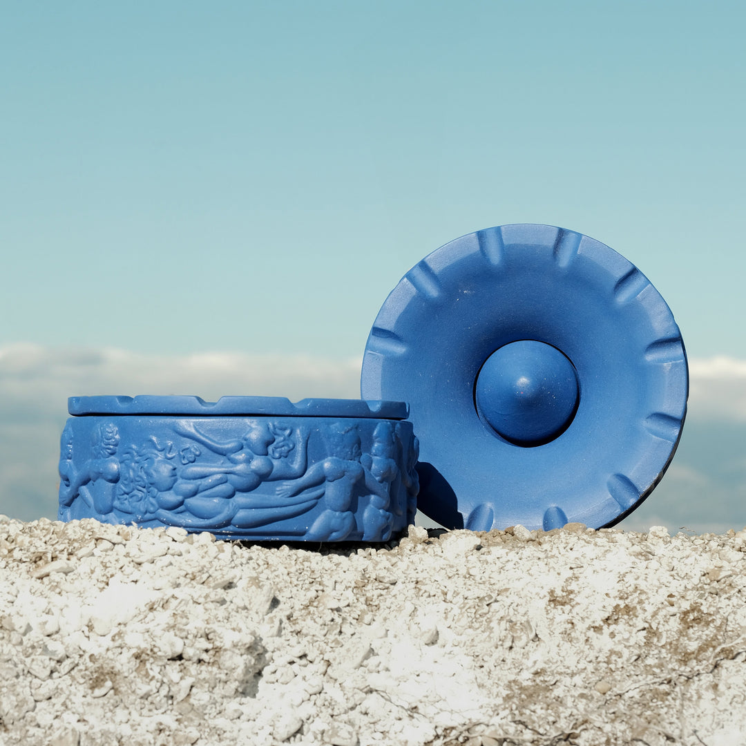 Seletti Magna Graecia Terracotta Ashtray Dialogues Blue, the blue ashtray and its lid on pale rock under a blue sky