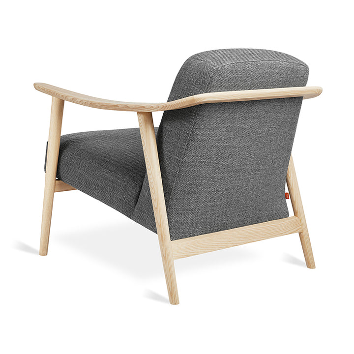 Mid-century modern armchair with oak frame and charcoal wool upholstery, showcasing clean lines and designer craftsmanship.