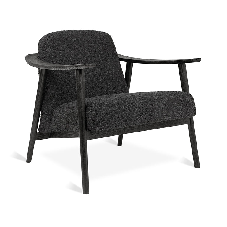 Black bouclé armchair with sleek wooden frame, modern designer furniture