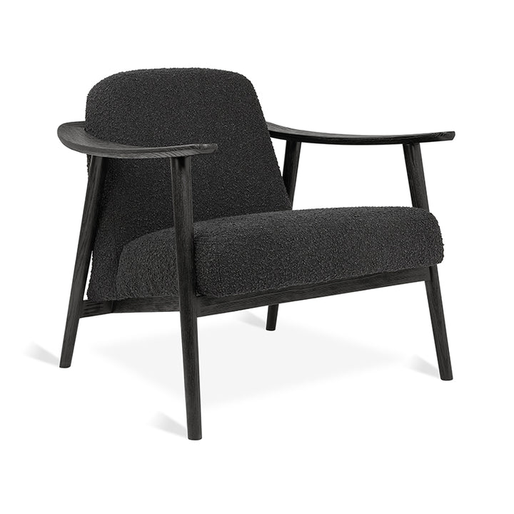 Black bouclé armchair with sleek wooden frame, modern designer furniture