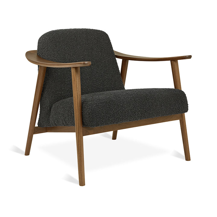 Mid-century modern armchair with dark bouclé upholstery and walnut wood frame