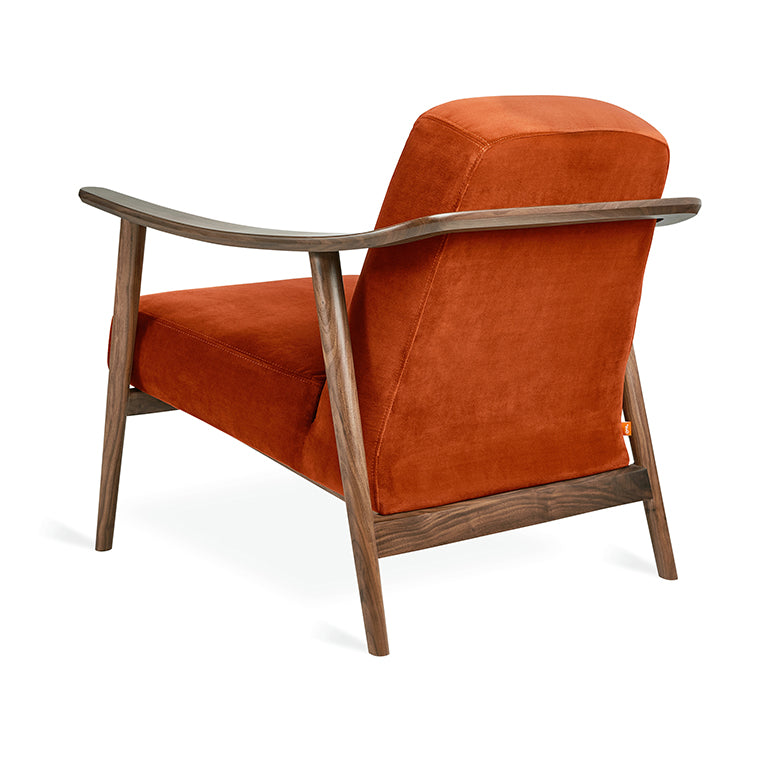 Rust velvet armchair with sculpted walnut frame, modern designer lounge chair