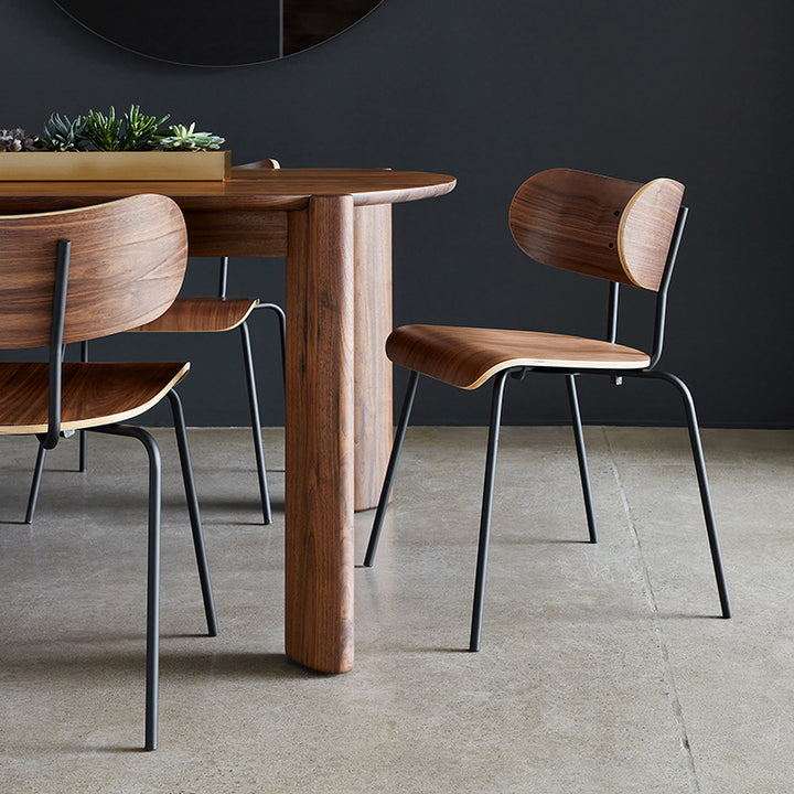 Walnut dining table with sleek black metal chairs, modern minimalist design