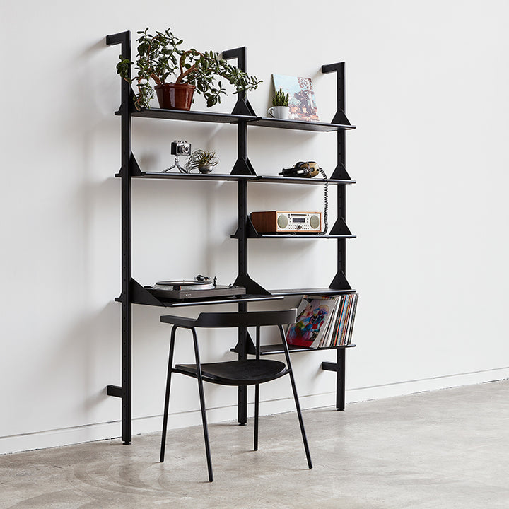 Black metal shelving unit with vinyl player, plants, and decor, styled for modern home interiors