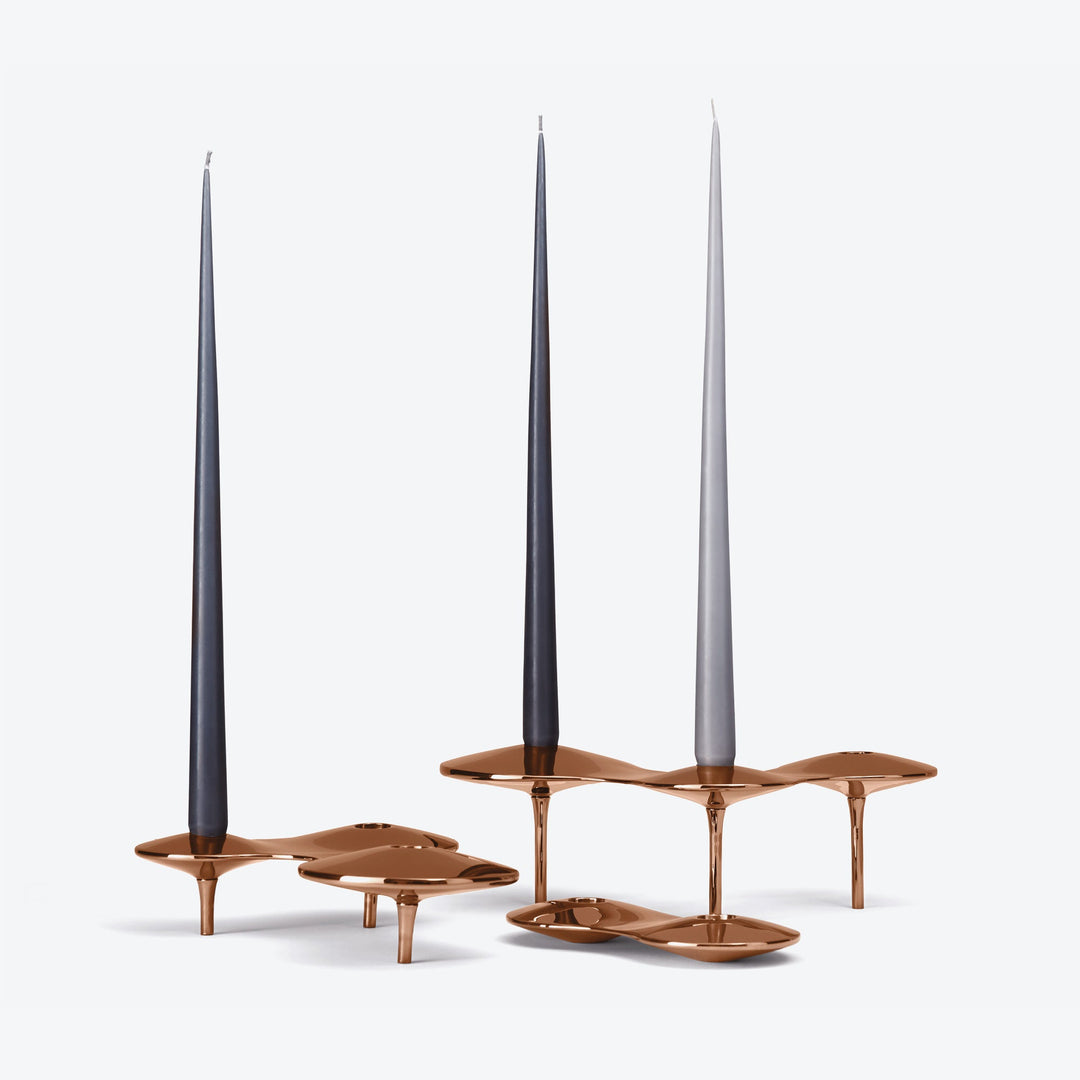 Cell Candle Holder — rose gold pieces in three sizes with dark and light grey tapered candles on white