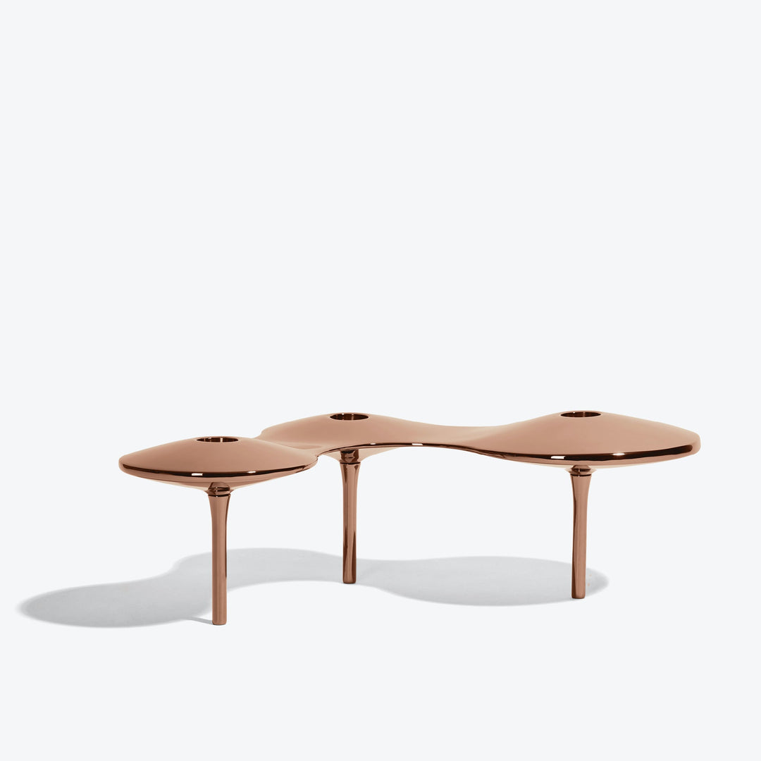Cell Candle Holder — large rose gold three-candle piece on tall legs, low side view on white