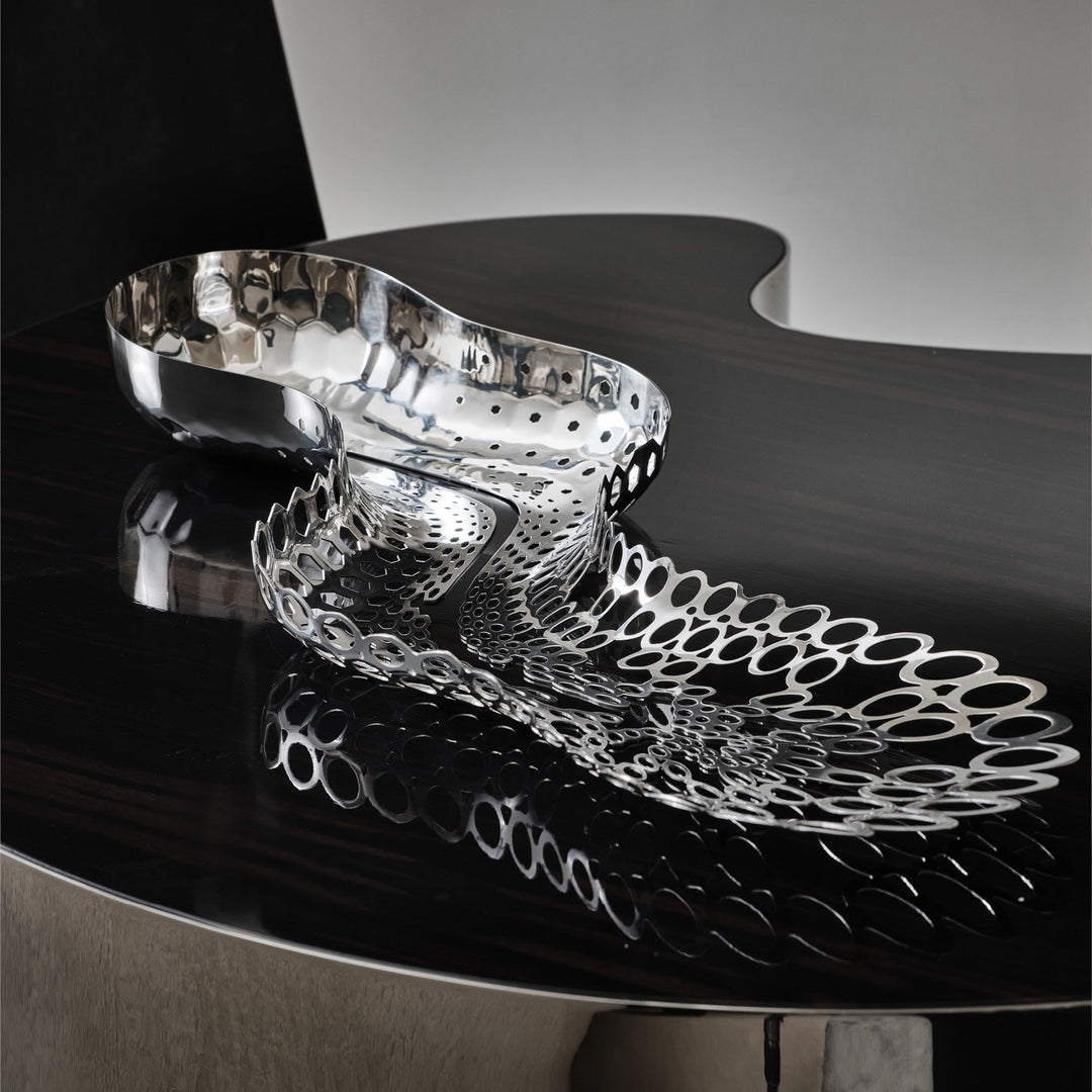 Cell Centerpiece — polished silver centerpiece on a dark glossy table with its reflection