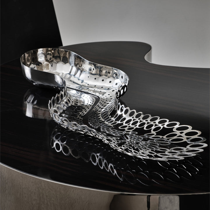 Cell Centerpiece — polished silver centerpiece on a dark glossy table with its reflection