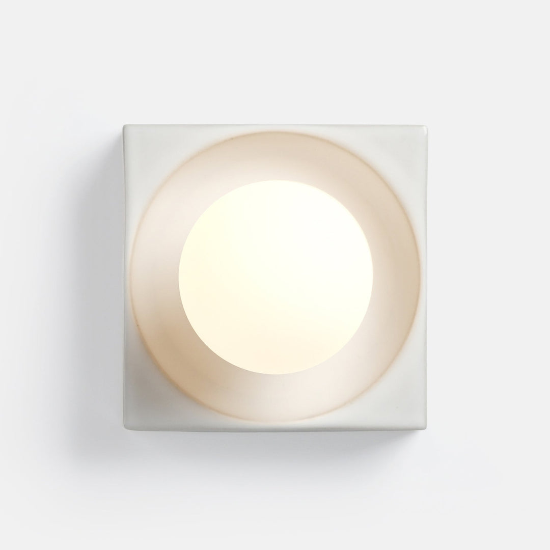 Square ceramic wall sconce with soft ambient glow, minimalist design