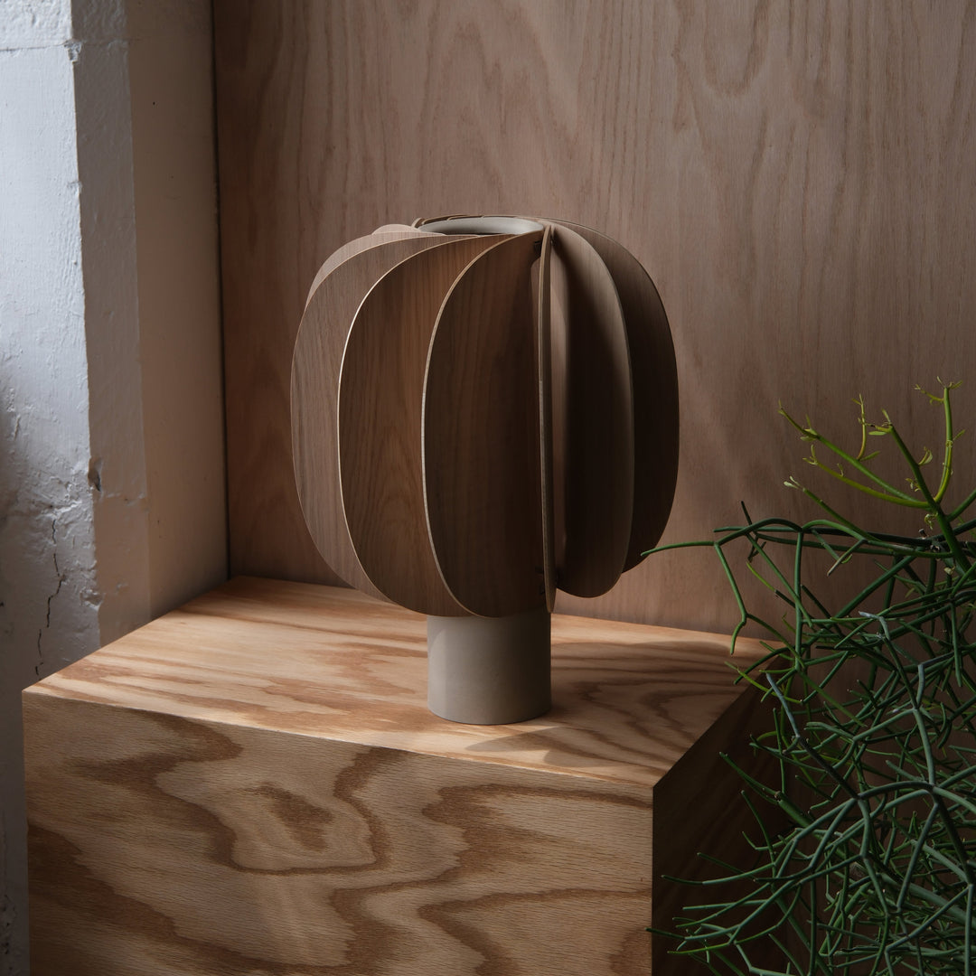 Wooden sculptural vase with layered petal design, styled on natural wood shelf