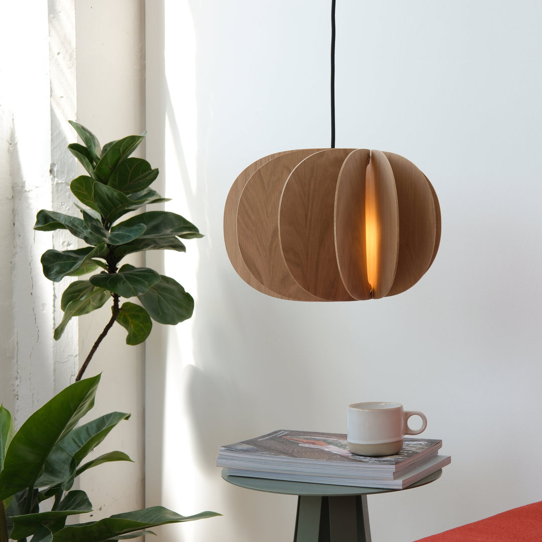 Wooden pendant lamp with warm glow, styled with greenery and modern decor