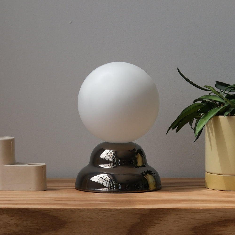 Frosted glass globe lamp with polished metal base, modern home decor