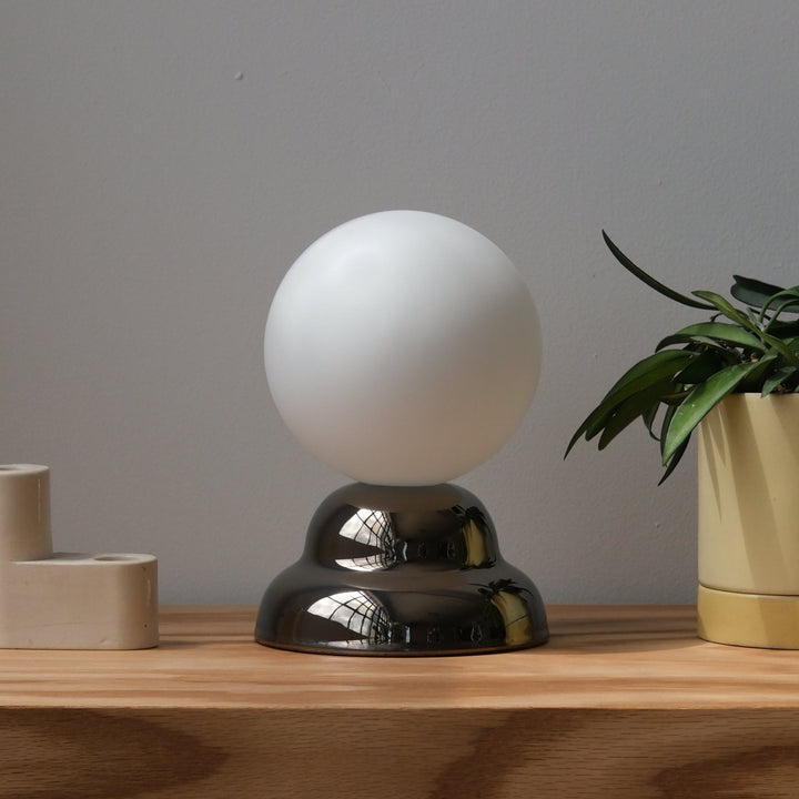 Frosted glass globe lamp with polished metal base, modern home decor