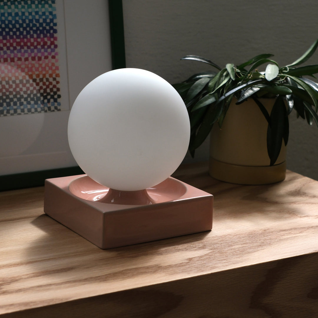 Matte white sphere lamp on blush ceramic base, modern home decor