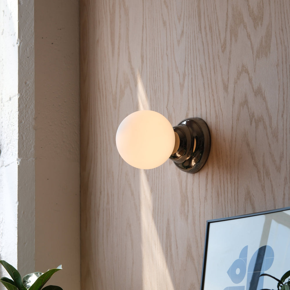 Sleek chrome sconce with frosted glass globe, modern wall lighting