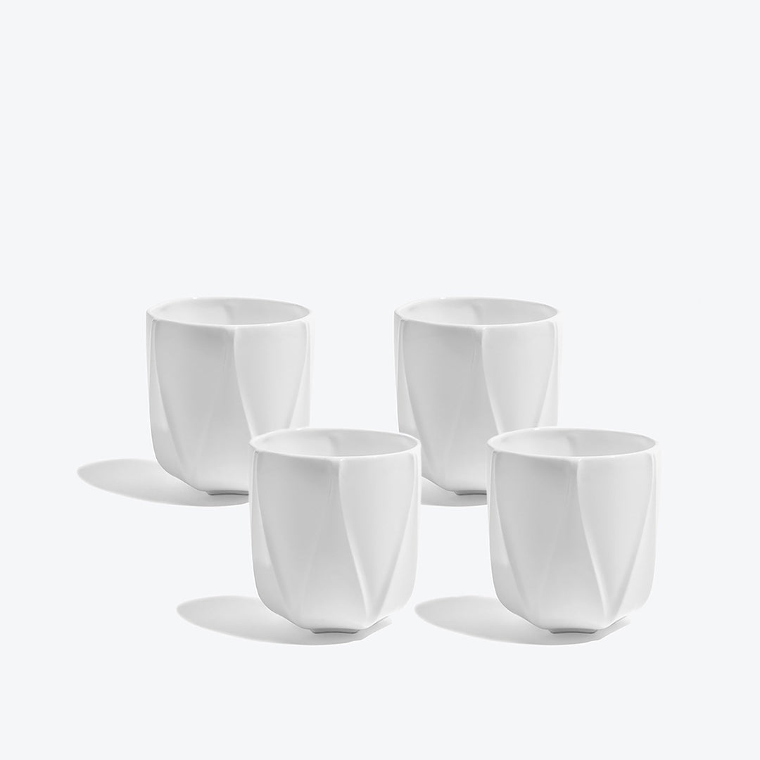 Folio Vessel, Set of 4 — four medium white faceted porcelain vessels arranged on a white background