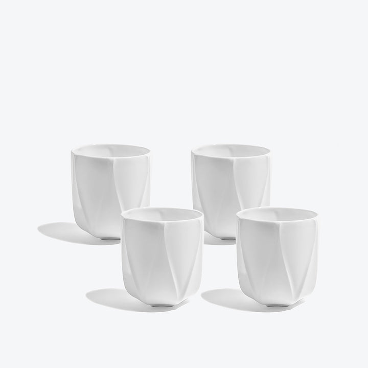 Folio Vessel, Set of 4 — four medium white faceted porcelain vessels arranged on a white background