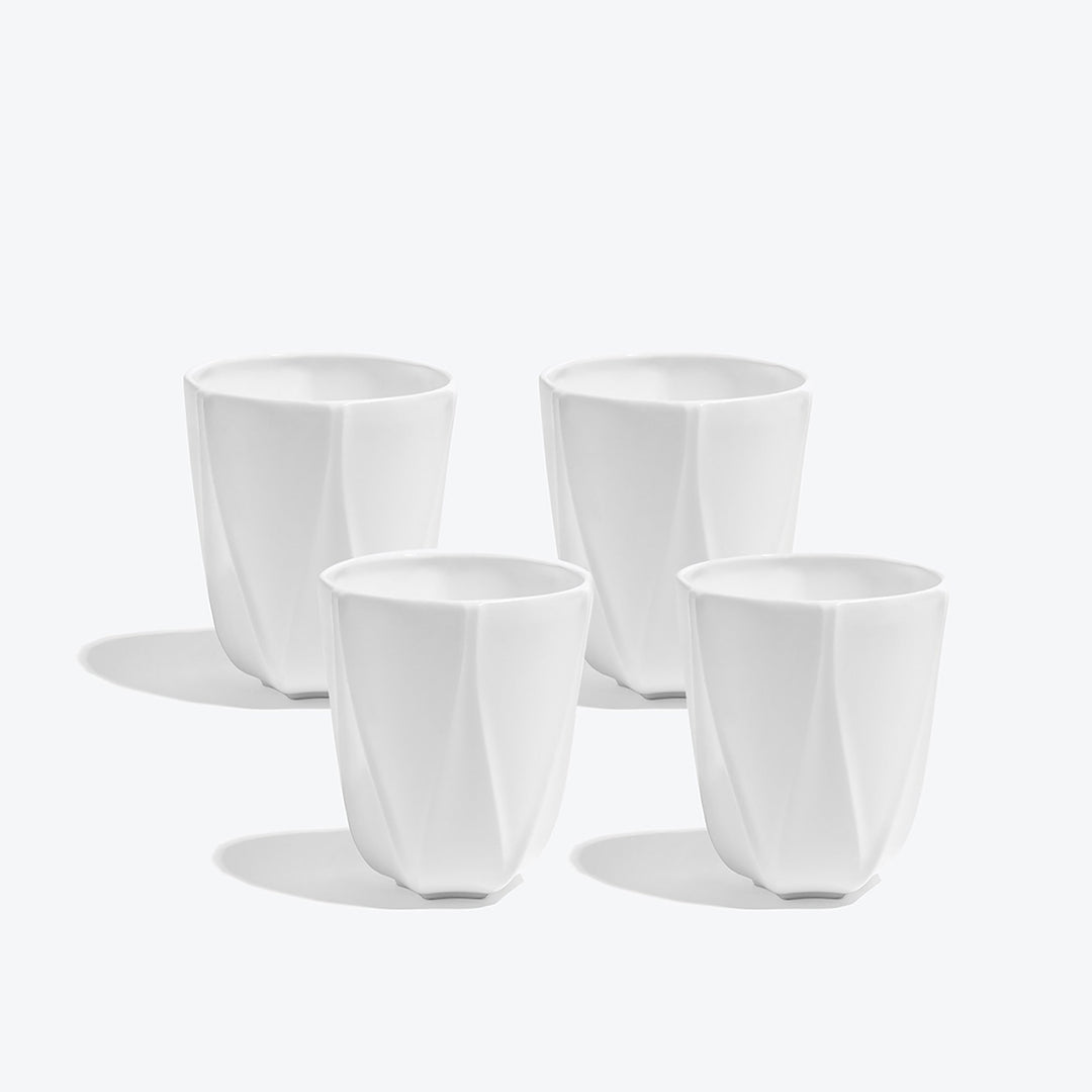 Folio Vessel, Set of 4 — four large white faceted porcelain vessels arranged on a white background
