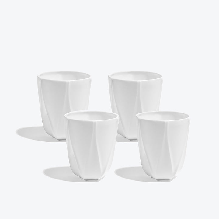 Folio Vessel, Set of 4 — four large white faceted porcelain vessels arranged on a white background