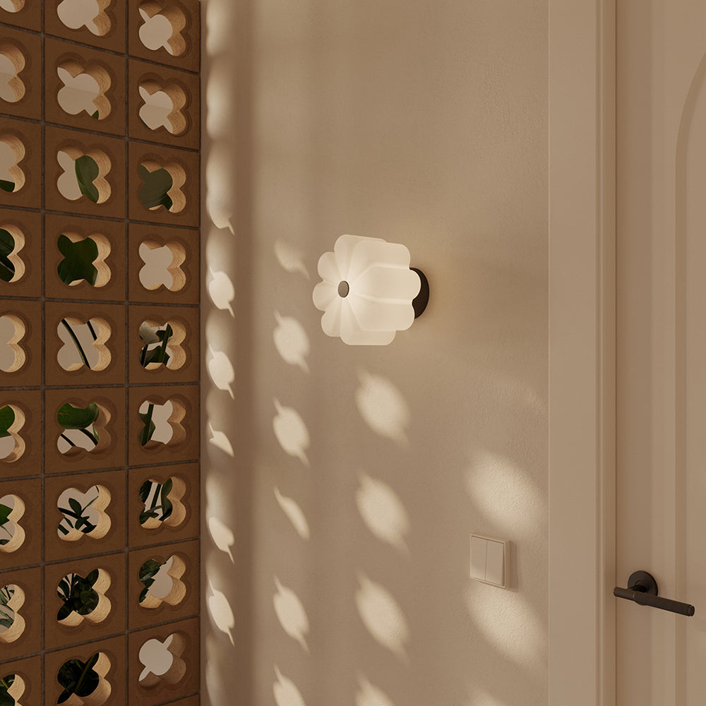 Flow Wall Lamp lit on a hallway wall beside a patterned breeze-block screen
