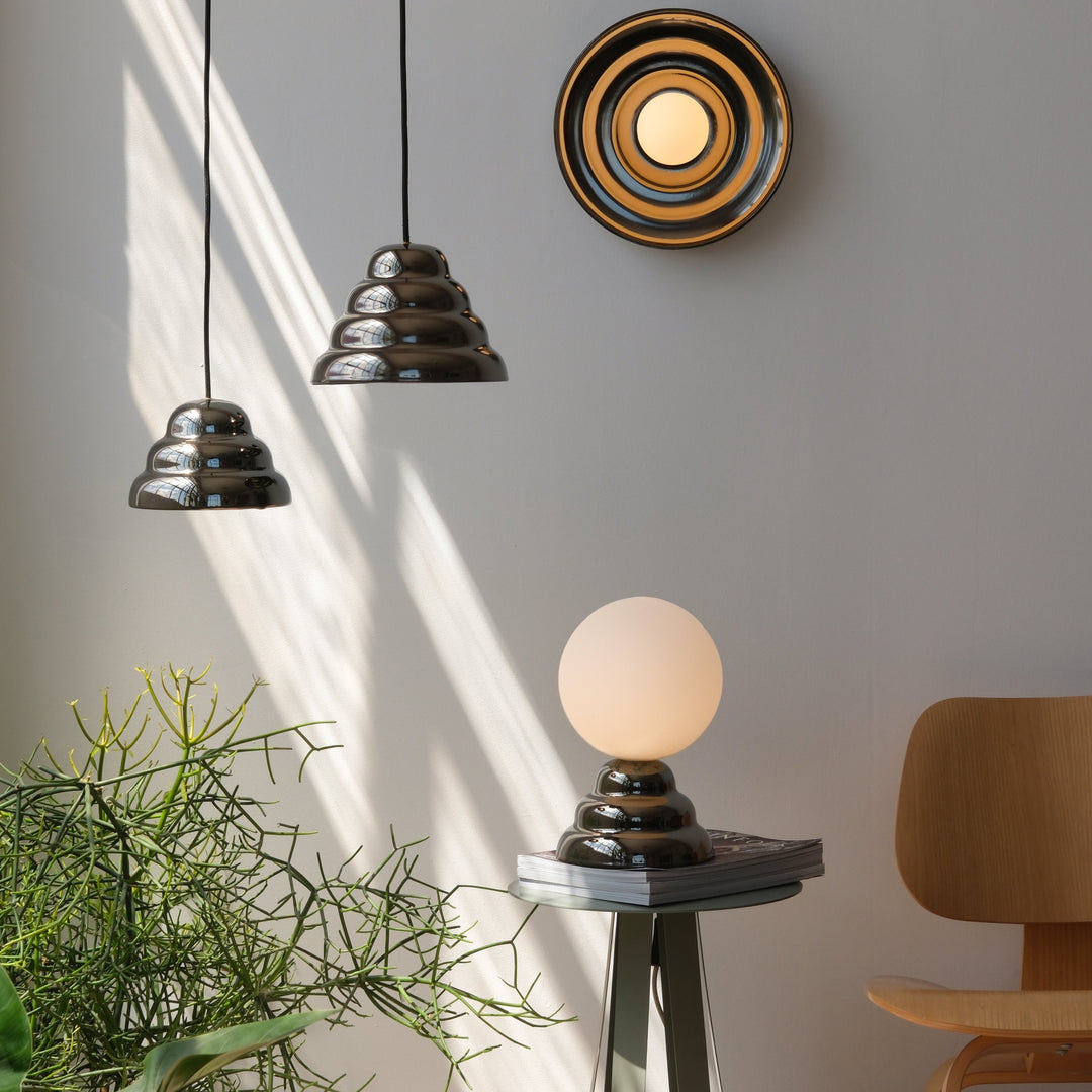 Sleek ceramic pendant lights and globe table lamp in modern home setting