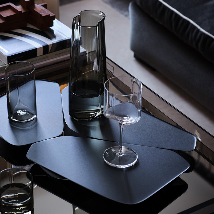 Hew Wine Glass, Set of 2 — Clear glass on a dark tray with a Smoke carafe and tumblers, coffee table setting