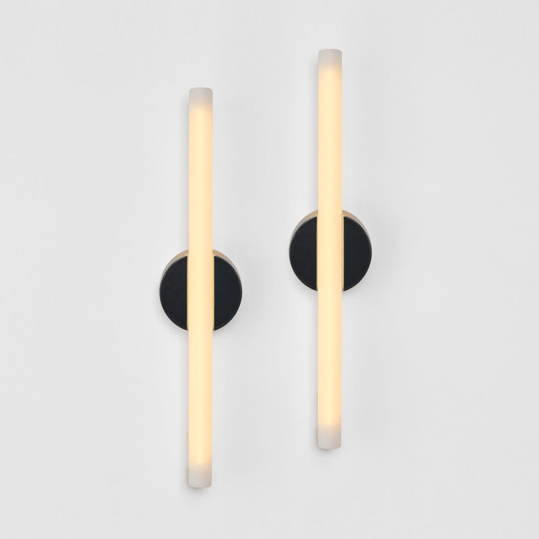 Modern wall sconces with frosted glass and matte black bases, minimalist design for elegant interiors