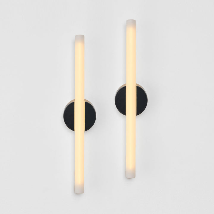 Modern wall sconces with frosted glass and matte black bases, minimalist design for elegant interiors