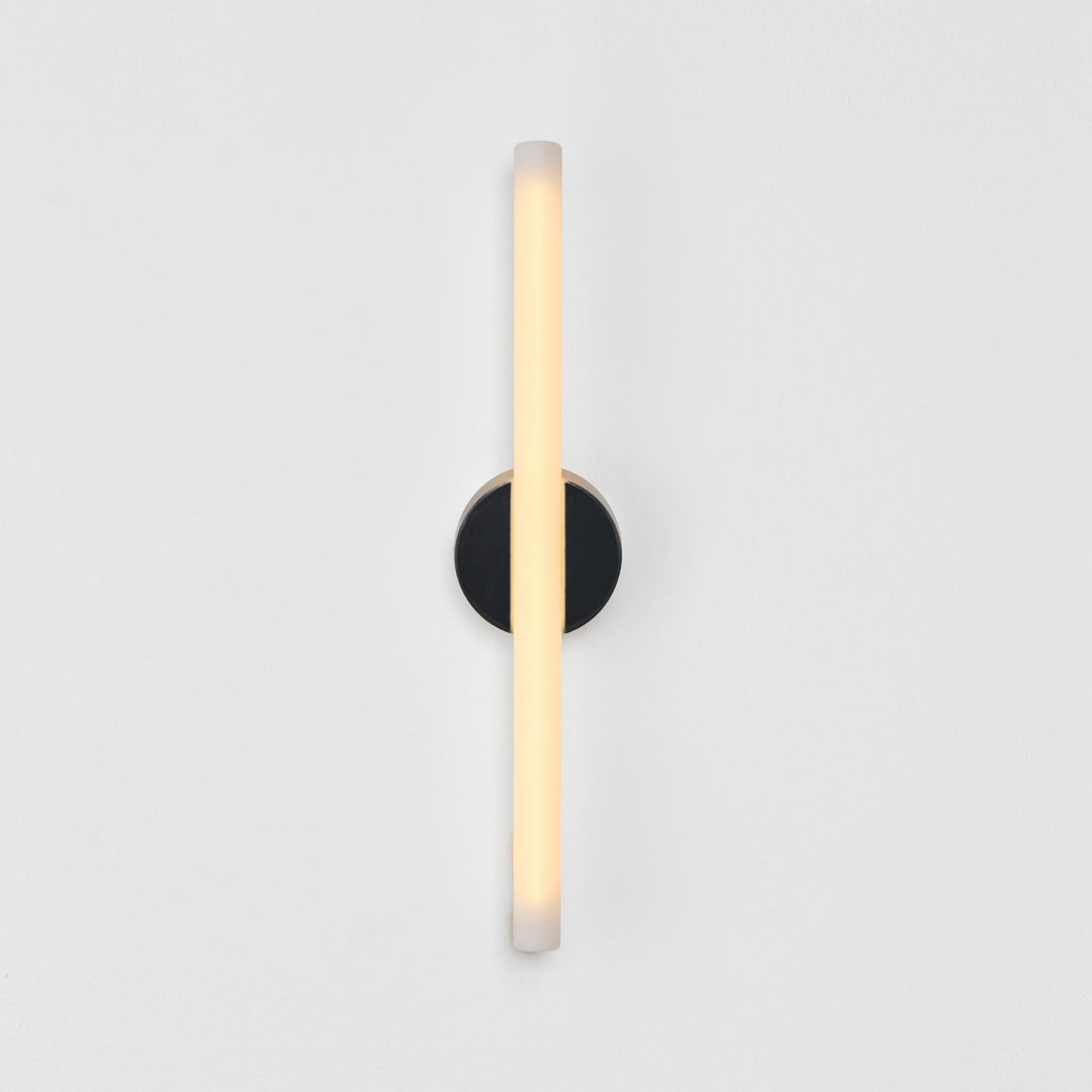 Modern wall sconce with frosted glass and matte black base, minimalist design for elegant interiors