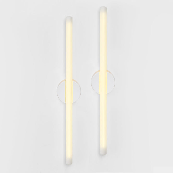 Modern frosted glass wall sconces with minimalist circular mounts, emitting warm ambient light for contemporary interiors.