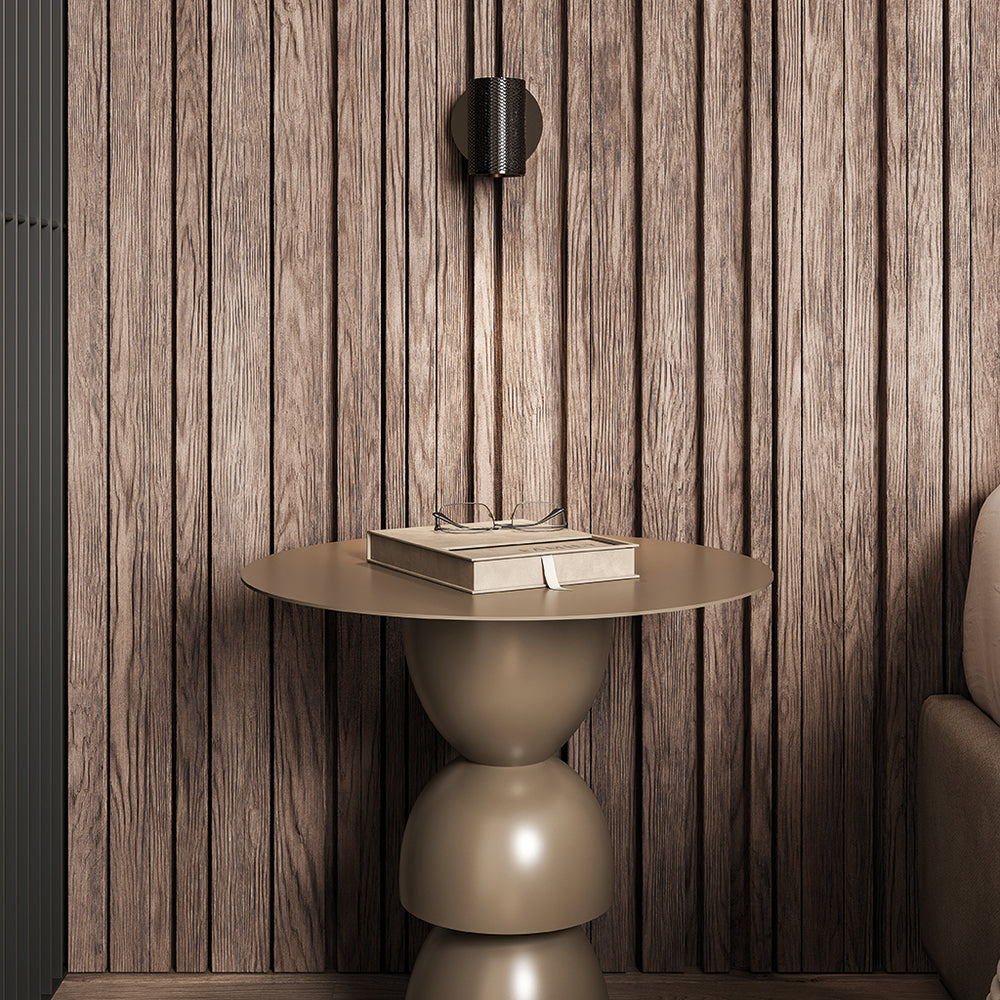 Latto Wall Lamp in black on a dark wood-slat wall above a round side table with books