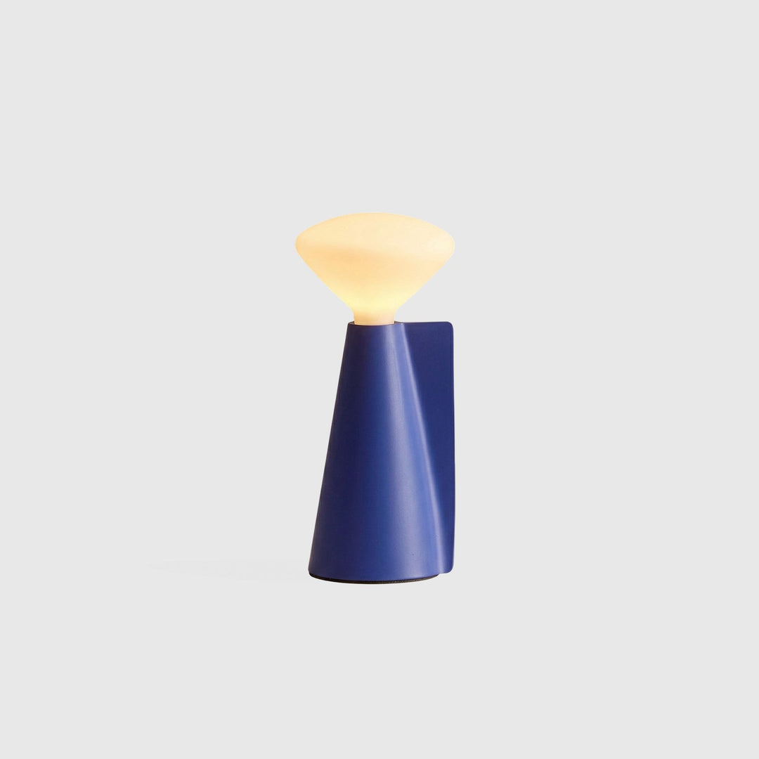 Modern blue ceramic table lamp with sculptural base and warm diffused glow, minimalist designer lighting