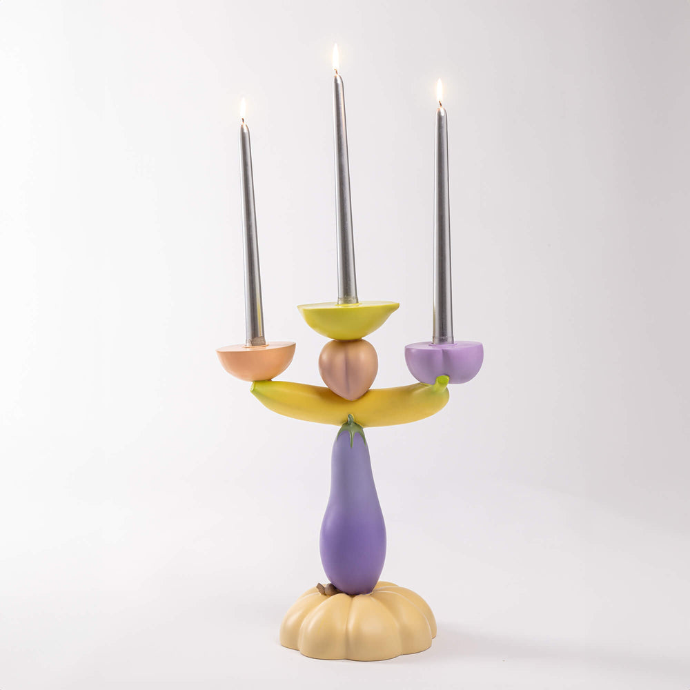 Seletti Vitamin Aubergine Candelabra, the candelabra with lit gray tapers on a pale backdrop