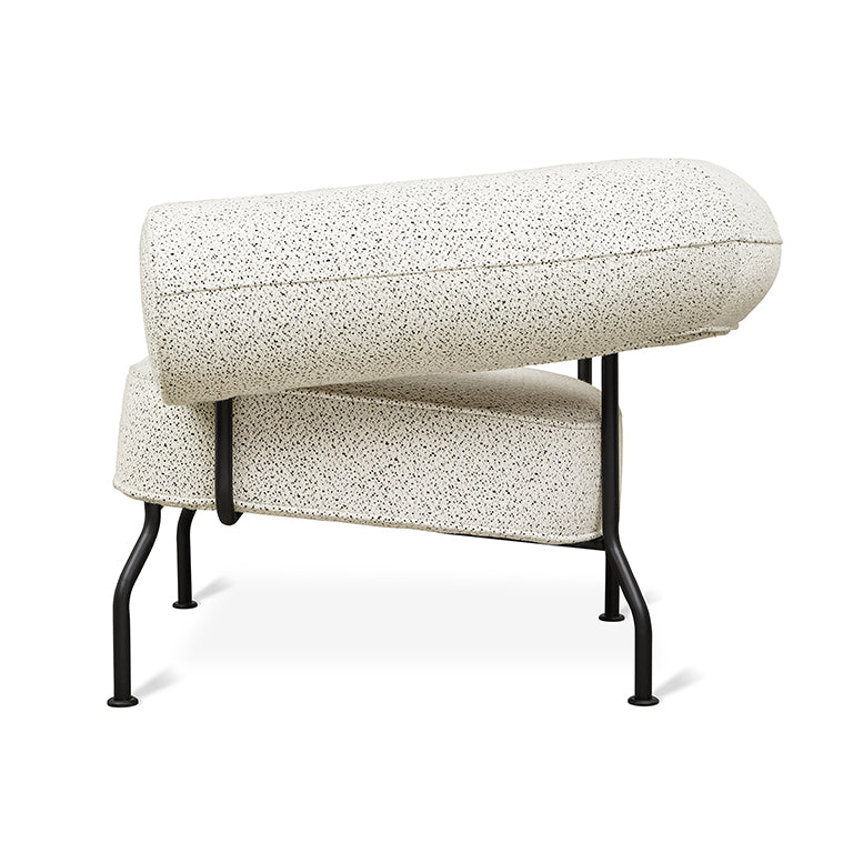 Sleek modern armchair with speckled cream upholstery and black metal frame, minimalist design